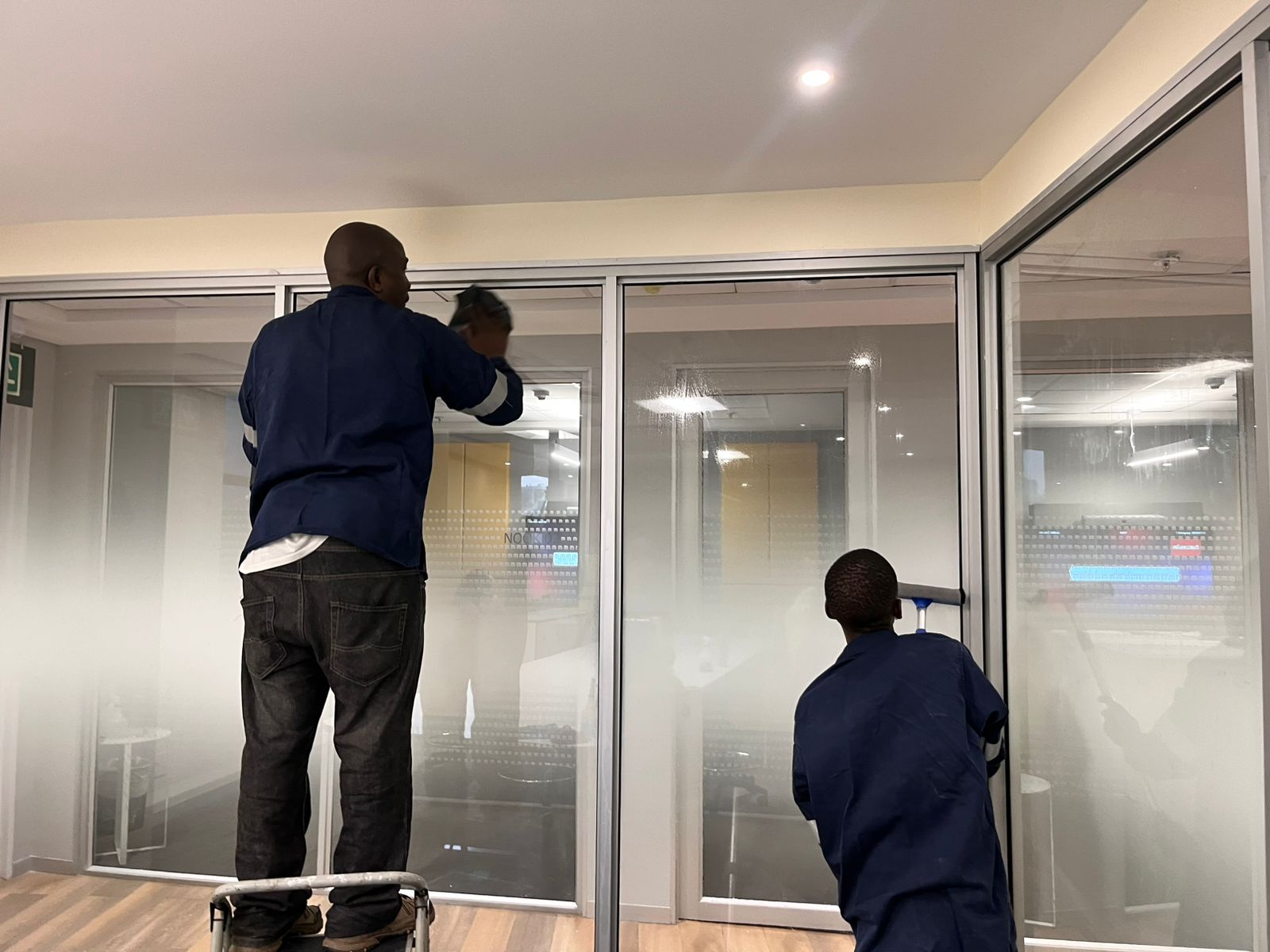 Workers cleaning large glass windows